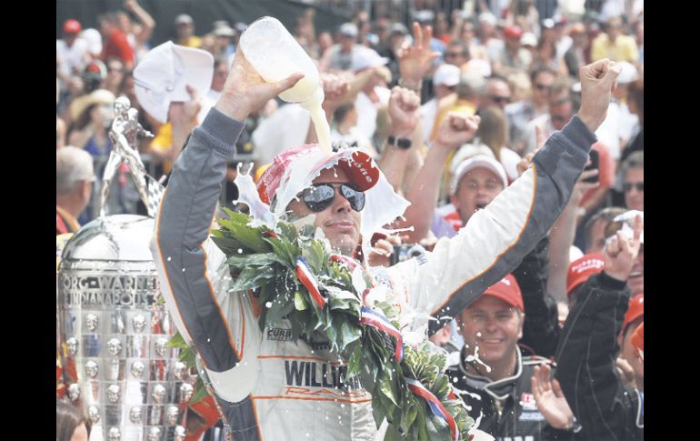 El inglés Dan Wheldon realiza el clásico festejo del ganador de la Indy 500 de tomar y derramarse leche. AP  /