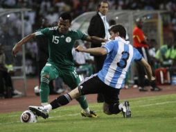 El nigeriano, Uche Ikechukwu, disputa el balón ante el argentino Insua Emiliano, durante partido amistoso. AP  /