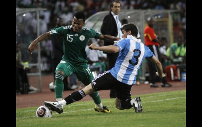 El nigeriano, Uche Ikechukwu, disputa el balón ante el argentino Insua Emiliano, durante partido amistoso. AP  /