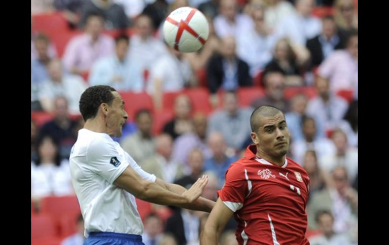 El jugador inglés Rio Ferdinand (i) lucha por el balón con el suizo Eren Derdiyok. EFE  /