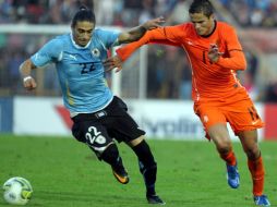 El jugador de Holanda Ibrahim Afellay (d) disputa el balón con Martín Cáceres (i) de Uruguay. EFE  /