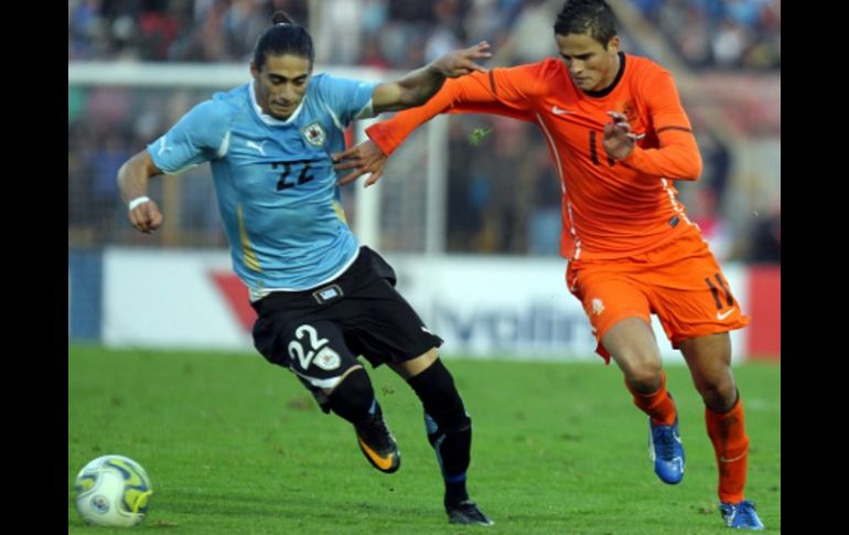 El jugador de Holanda Ibrahim Afellay (d) disputa el balón con Martín Cáceres (i) de Uruguay. EFE  /