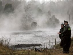 Un policía observa el agua del río Nilahue, afectado por las piedras volcánicas arrastradas a raíz de la erupción. EFE  /