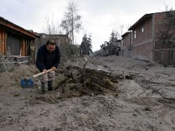 Un hombre hace una zanja en el lugar que quedo cubierto por la ceniza volcánica. AFP  /