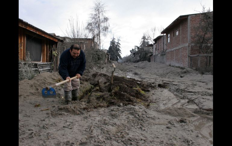 Un hombre hace una zanja en el lugar que quedo cubierto por la ceniza volcánica. AFP  /