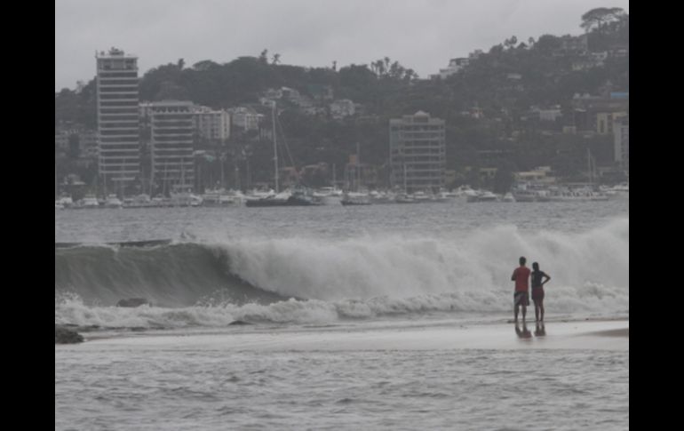 Personas observan el alto oleaje que ha generado la tormenta tropical en Acapulco. NTX  /