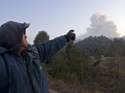 Un residente señala hacia la nube de ceniza que salía del volcán. AFP  /