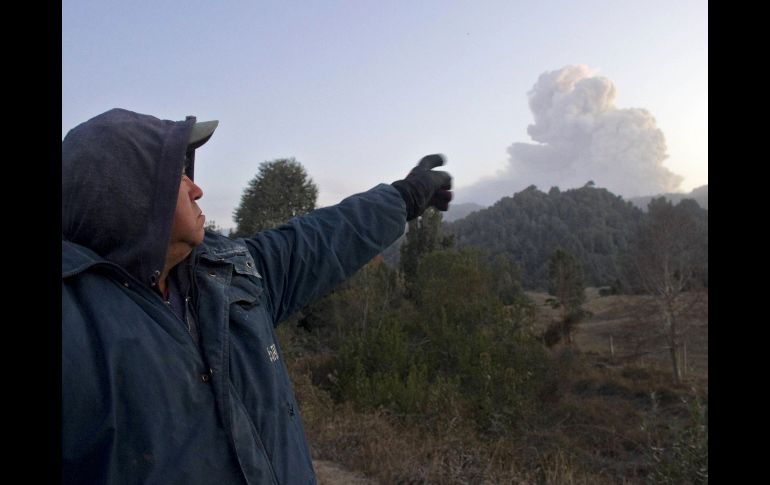 Un residente señala hacia la nube de ceniza que salía del volcán. AFP  /