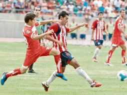 Patricio Araujo (der.) intenta controlar el esférico ante la marca escarlata. ESPECIAL  /