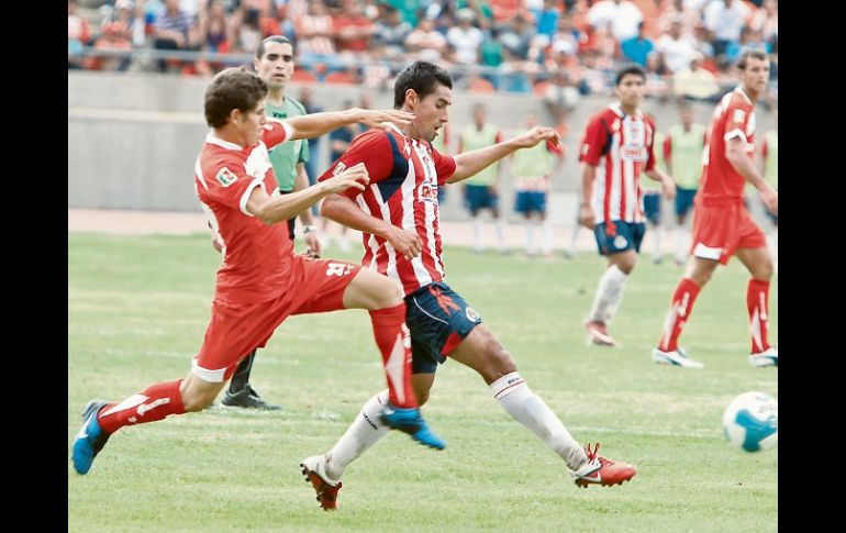 Patricio Araujo (der.) intenta controlar el esférico ante la marca escarlata. ESPECIAL  /