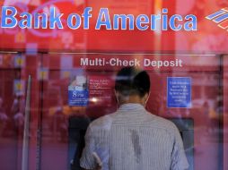 Un hombre saca dinero de un cajero automático en una sucursal del Bank of America en Times Square, NY. ARCHIVO  /