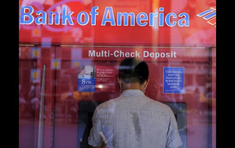 Un hombre saca dinero de un cajero automático en una sucursal del Bank of America en Times Square, NY. ARCHIVO  /