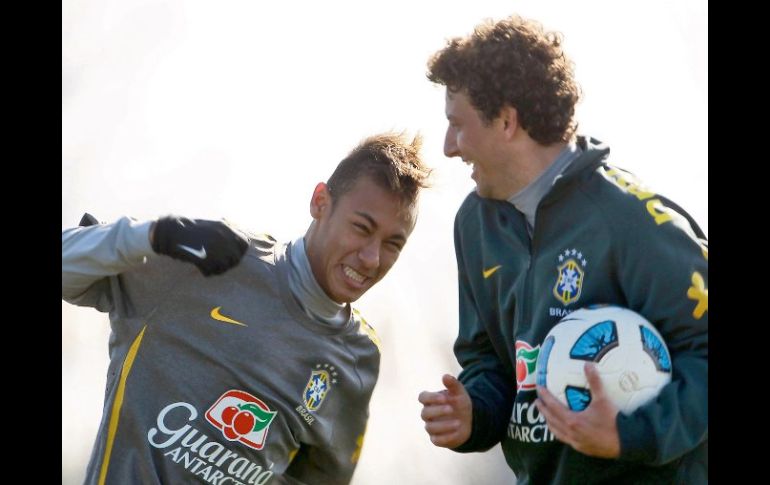 Neymar bromea con su compañero Elano, durante el entrenamiento de Brasil. AP  /