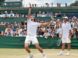 El actual campeón de Wimbledon, Rafael Nadal, ejecuta su servicio ante la mirada de su tío y entrenador, Toni Nadal, durante una prácti  /