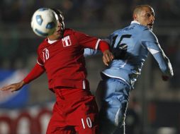 El centrocampista uruguayo Diego Pérez disputa un balón al centrocampista peruano Paulo Cruzado. EFE  /