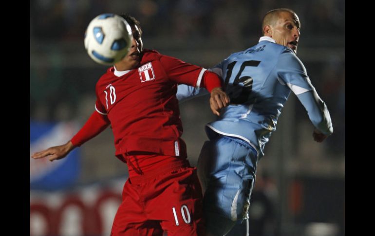 El centrocampista uruguayo Diego Pérez disputa un balón al centrocampista peruano Paulo Cruzado. EFE  /