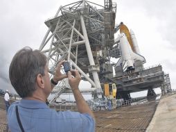 Un hombre le toma una fotografía al transbordador espacial. AP  /