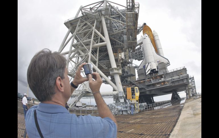 Un hombre le toma una fotografía al transbordador espacial. AP  /