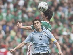 El capitán de Uruguay, Emiliano Velázquez (2) disputa la pelota con el mexicano Marco Bueno. MEXSPORT  /