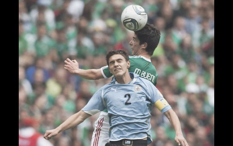 El capitán de Uruguay, Emiliano Velázquez (2) disputa la pelota con el mexicano Marco Bueno. MEXSPORT  /