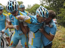 El kazako es ayudado por su equipo después de la caída en la novena etapa del Tour de Francia. AP  /