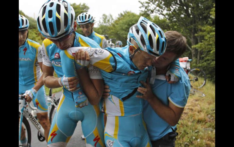 El kazako es ayudado por su equipo después de la caída en la novena etapa del Tour de Francia. AP  /