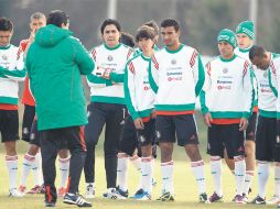 Luis Fernando Tena (de espalda) dialoga con sus jugadores previo al entrenamiento. EFE  /