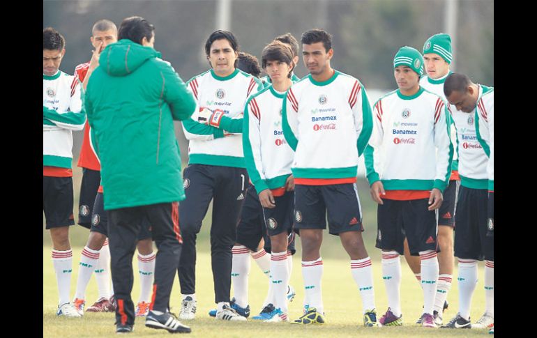 Luis Fernando Tena (de espalda) dialoga con sus jugadores previo al entrenamiento. EFE  /