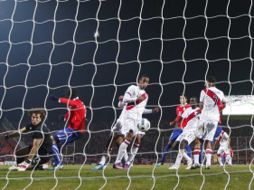 Momento en el que el balón es impulsado por Corzo para el autogol que dio la victoria a Chile. AP  /