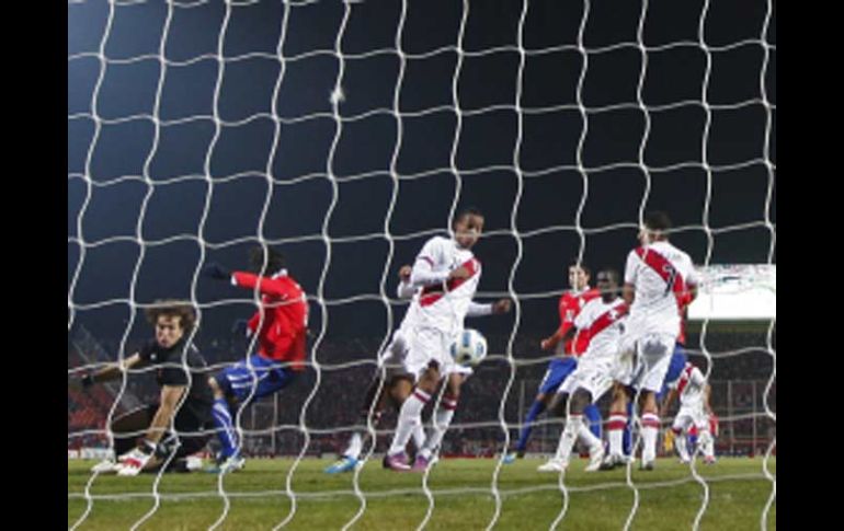 Momento en el que el balón es impulsado por Corzo para el autogol que dio la victoria a Chile. AP  /