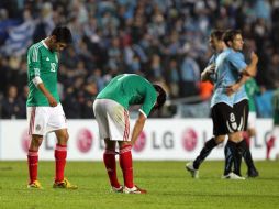 Los mexicanos Oribe Peralta y Rafael Márquez lamantan la derrota ante Uruguay. EFE  /