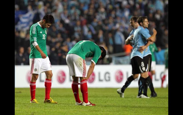 Los mexicanos Oribe Peralta y Rafael Márquez lamantan la derrota ante Uruguay. EFE  /