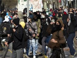 Estudiantes lanzan piedras contra la policía antidisturbios durante una protesta contra el gobierno de Sebastián Piñera. AFP  /