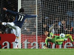 El portero uruguayo Muslera (der.) fue la pieza clave al detener un penal a Carlos Tévez de Argentina. AFP  /