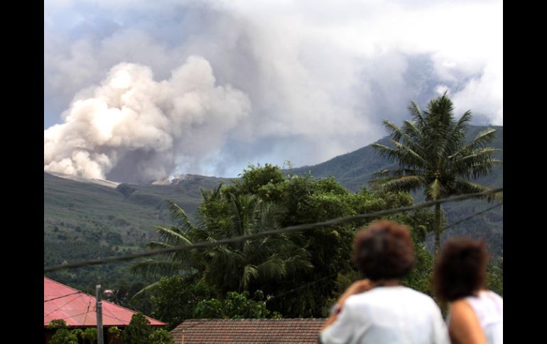 Dos residentes observan el Monte  Lokon  arrojando  ceniza volcánica durante una erupción. REUTERS  /