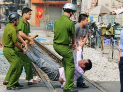 Oficiales de la policía vietnamita arrastran a un  manifestante. AP  /