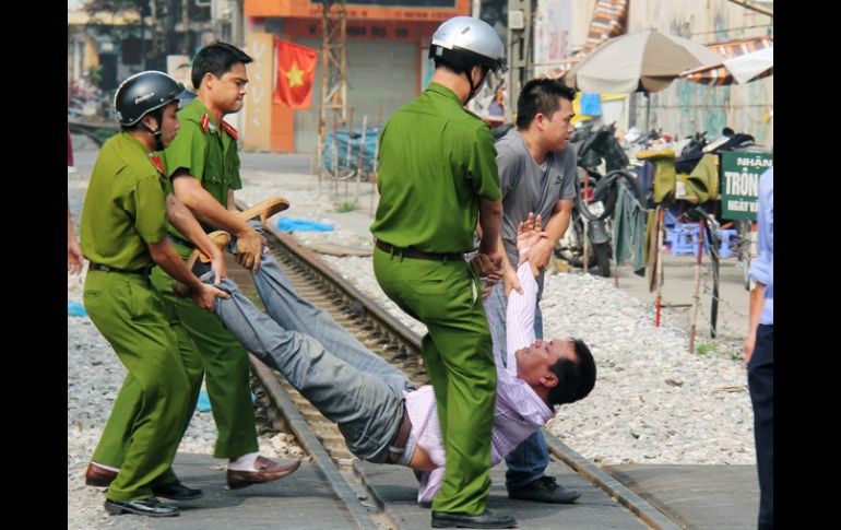 Oficiales de la policía vietnamita arrastran a un  manifestante. AP  /