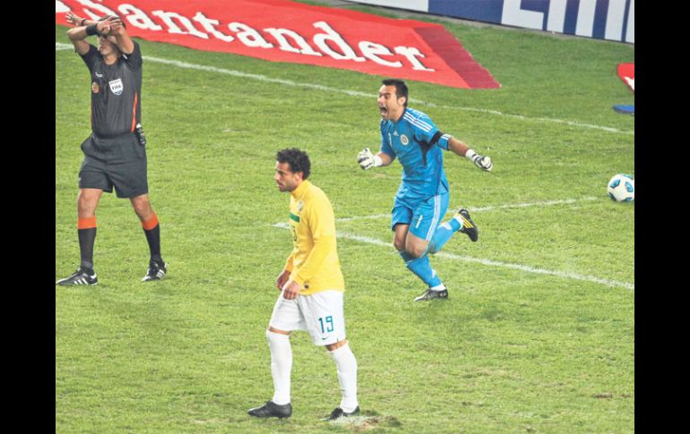 El guardameta de Paraguay Justo Villar (izq.) festeja luego que Fred, de Brasil, fallara el penal decisivo. EFE  /