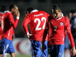 Los chilenos Alexis Sánchez (Der), Esteban Paredes (Izq) y Arturo Vidal abandonan el campo tras perder ante Venezuela. EFE  /