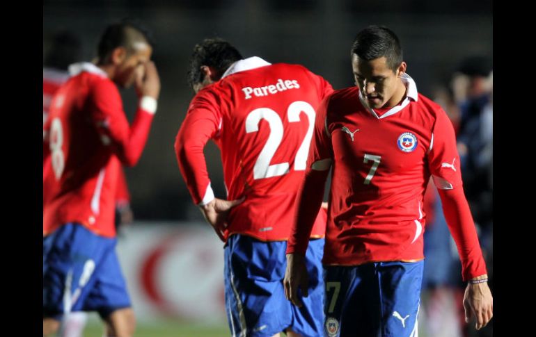 Los chilenos Alexis Sánchez (Der), Esteban Paredes (Izq) y Arturo Vidal abandonan el campo tras perder ante Venezuela. EFE  /