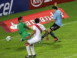 Luis Suárez (der.) dispara ante la salida del portero de Perú para anotar el primer gol del partido. REUTERS  /