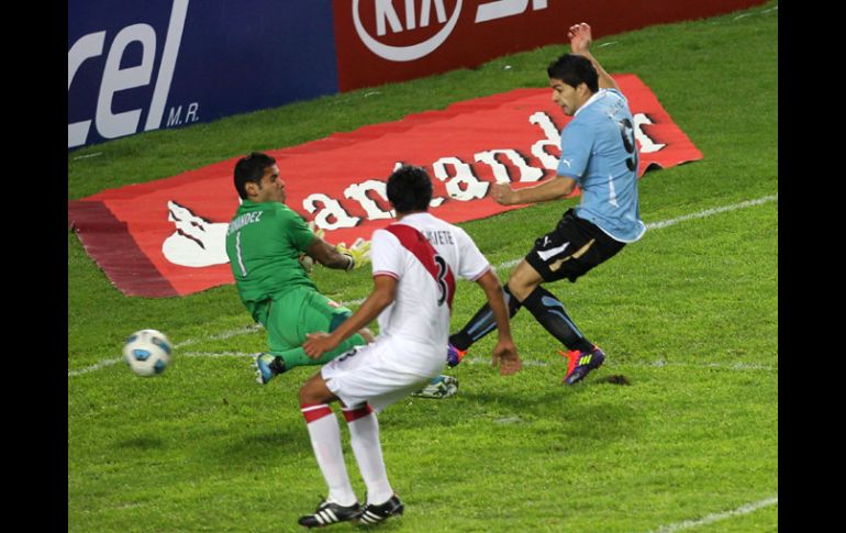 Luis Suárez (der.) dispara ante la salida del portero de Perú para anotar el primer gol del partido. REUTERS  /