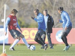 Diego Lugano (izq.) disputa la pelota con el atacante Abel Hernández ante la mirada del mediocampista Álvaro Pereira. AFP  /