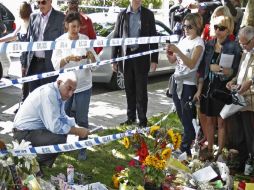 Durante la jornada, los seguidores siguen llevando flores y fotografías afuera de donde vivía Winehouse. REUTERS  /