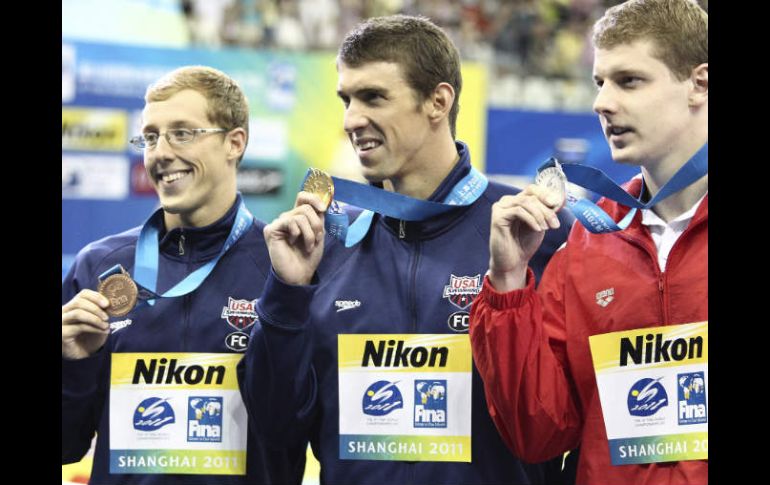 Michael Phelps (centro) junto al ganador de la plata, Konrad Czerniak (der) y del bronce, Tyler McGill (izq) en la premiación. EFE  /