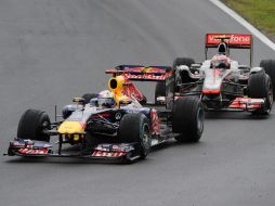 El piloto de Red Bull, Sebastian Vettel (izq) compite con el de McLaren, Jenson Button, durante el GP húngaro. AFP  /