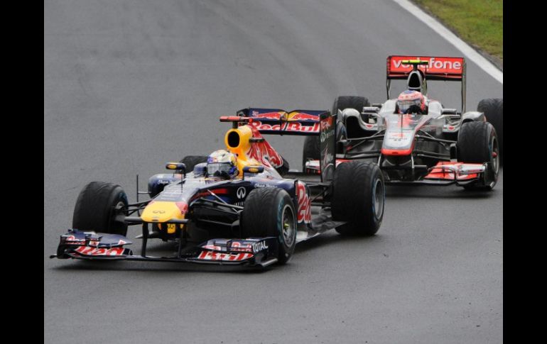 El piloto de Red Bull, Sebastian Vettel (izq) compite con el de McLaren, Jenson Button, durante el GP húngaro. AFP  /