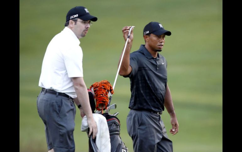 Byron Bell (I), amigo de la infancia de Woods, actuará mientras tanto como su caddie provisional.AFP  /