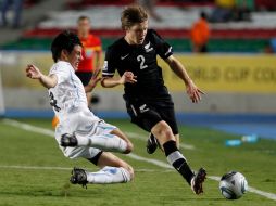 El uruguayo Guillermo de Los Santos (i) y Andrew Bevin, de Nueva Zelanda, disputan un balón. AP  /