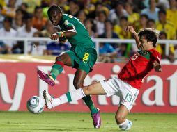 Emmanuel Mbongo, de Camerún, intenta un tiro mientras Luis Martins, de Portugal, busca bloquearlo. AP  /